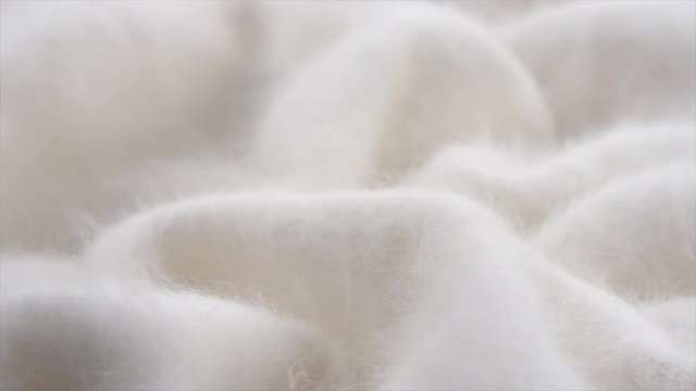 Soft wool background. Alpaca wool mohair clothes texture closeup. Natural cashmere fluffy merino wool. Woolen fabric. Rotated. 4K UHD video footage. 3840X2160