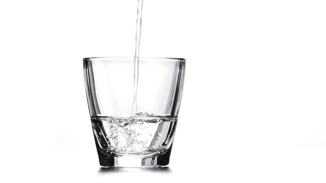 Pouring fresh pure water from bottle into a glass on the table, Isolate on white background, Slow motion footage