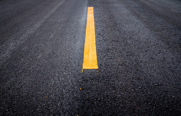 Asphalt road surface with yellow line