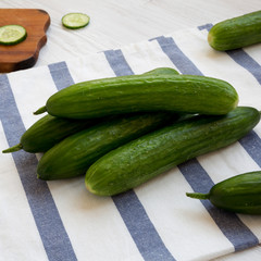 Fresh raw organic green cucumbers on cloth, side view. Closeup.