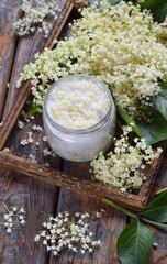 Elderflower sugar and blossom flower in wooden background. Edible elderberry flowers add flavour...
