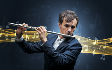 Young male musician playing on his flute with musical notes around © ra2 studio