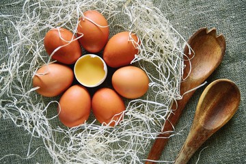 Farm fresh eggs lie on the surface of the table with a wooden spoon, ready-to-cook healthy papneja.