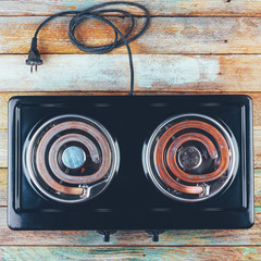 electric stove with two electric forks on a wooden table, top view close-up