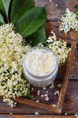 Elderflower sugar and blossom flower in wooden background. Edible elderberry flowers add flavour...