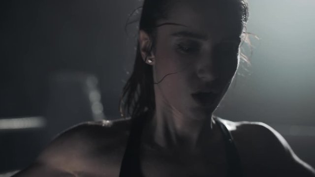 Young boxer girl with boxing gloves screams emotionally standing on the boxing ring. Slow motion