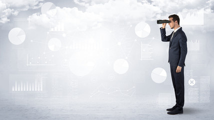 Businessman looking forward with binoculars cloudy background and graphs, charts around
