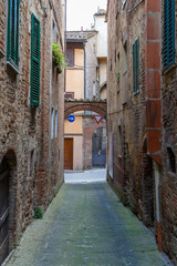 Colourful narrow street in an ancient Italian town. Vertical picture. Travel Italy.