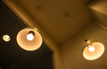 Lighting fixture lamps are hanging on textile classic cable from the ceiling