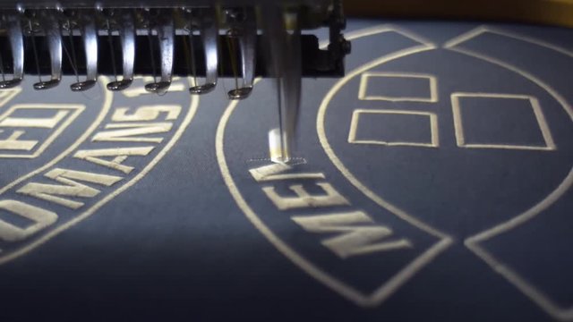 Modern Embroidery machine. Stitching together logos.