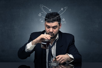 Young drunk man at his office with doodles around
