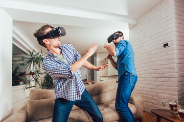 Happy friends playing video games with virtual reality glasses - Young people having fun with new technology console online