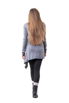 Back view of elegant young woman with long dark blonde hair walking away leaving. Full body isolated on white background. 