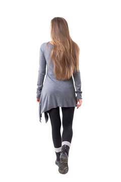 Rear view of casual young stylish woman with long flowing hair leaving. Full body isolated on white background. 