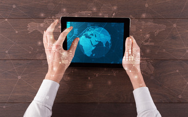 Hand touching tablet with worldwide reports links and statistics concept
