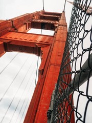 Fototapeta premium Details of the Golden gate bridge in San Francisco, close photographed metal mounts, from the side of the road with cars