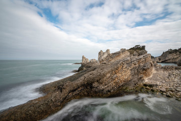 Black sea and the beach with rocks and waves with cloudy sky, 