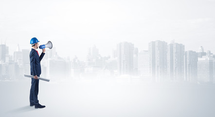 Young supervisor architect standing and looking at a big city panorama
