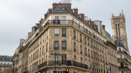 Fototapeta na wymiar Paris, beautiful building rue de Rivoli, typical parisian facades and windows, with the Saint-Jacques tower in background