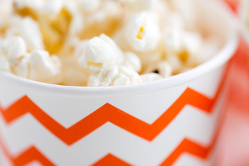 fast food, junk-food and unhealthy eating concept - close up of popcorn in disposable paper cups...