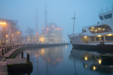 Fototapeta na wymiar Foggy day, Ortaköy Mosque and Passenger Ferry in Istanbul, Turkey. 