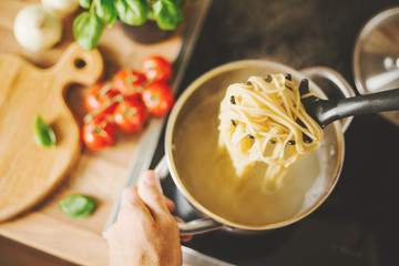 Man holding spoon with steaming pasta