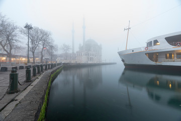 Foggy day, Ortak&ouml;y Mosque and Passenger Ferry in Istanbul, Turkey.