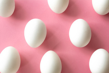 White eggs on pink background, flat lay
