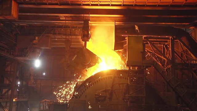The process of pouring iron into the converter. Steel production at a metallurgical plant.