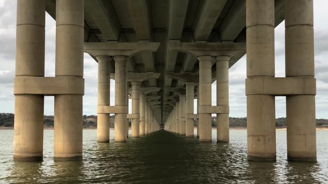Lake Belton gently flows underneath a symmetrical bridge in Temple, Texas.