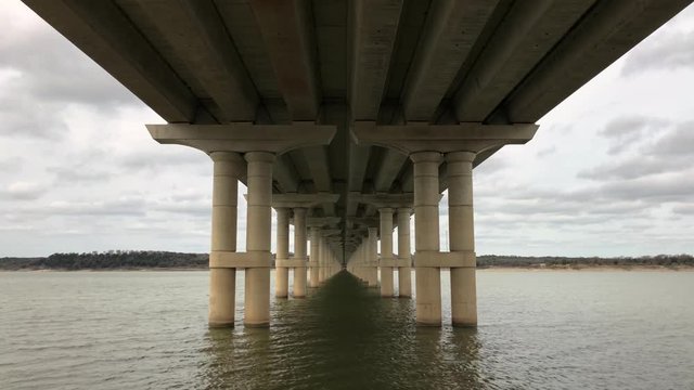 Lake Belton gently flows underneath a bridge in Texas as clouds pass by. 4k, 24 fps.