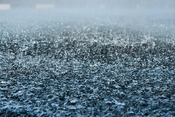 Drops of heavy rain in a puddle on the asphalt road. A Stream of water that floods all around....