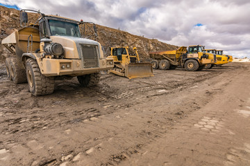 Fleet of trucks and an excavator on a construction site
