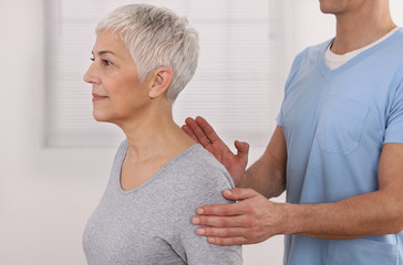 Mature Woman having chiropractic back adjustment. Osteopathy, Physiotherapy, Sport injury...