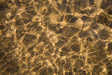Fototapeta na wymiar Crystal clear water moving on sand