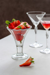Glass with strawberries and a couple of martini glasses