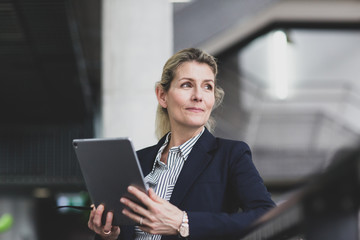 Senior female business executive using digital tablet in a corporate office