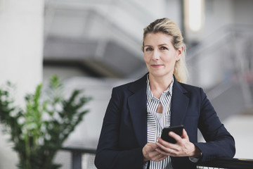 Portrait of senior female business executive holding a smartphone