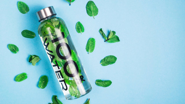 Transparent bottle of water with a metal cap - 100 percent water. Top view, flat lay, copy space. - Powered by Adobe