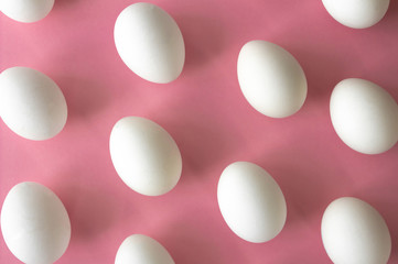 High angle view of isolated white eggs on pastel pink background. Minimal concept
