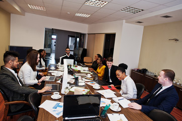 Multiracial young creative people in modern office. Group of young business people are working together with laptop, tablet. Successful freelancers team in coworking.