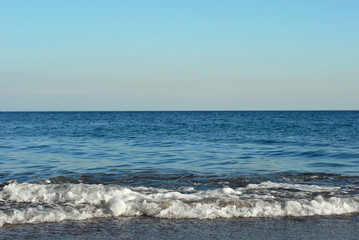 Fototapeta na wymiar Rocky coast of the sea. Waves on the beach. Blue sea water.