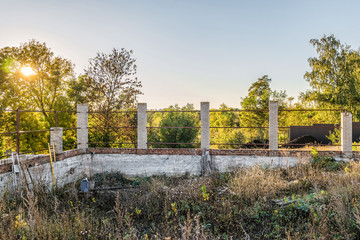 Construction of a metal frame fence with brick posts