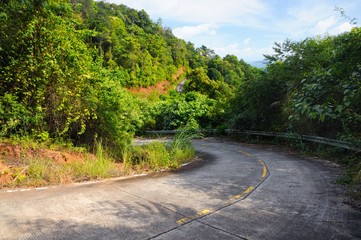 Winding mountain road through rainforest at the coastline of the Koh Chand Island, Thailand.