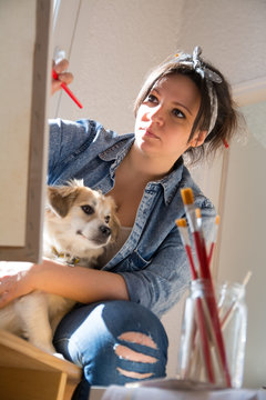 Beautiful woman painting with her dog