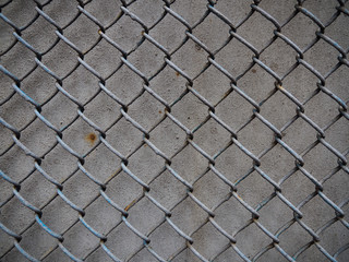 Metal wire mesh on the background of a gray wall
