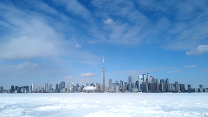 View of Toronto city skyline form Toronto Islands across frozen lake Ontario