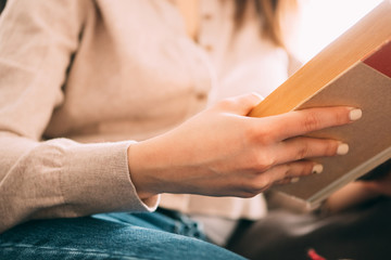 Girl reading a book at home on the couch
