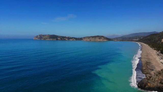 4k Aerial above turquoise Sea Waves Splashing On rocky cilento Coast with street and cars
