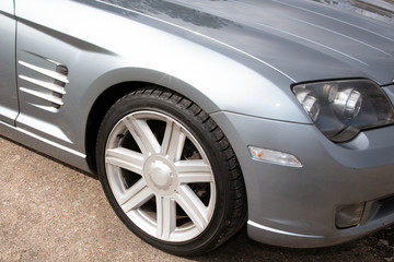 Car wheel rim front of gray sport automobile